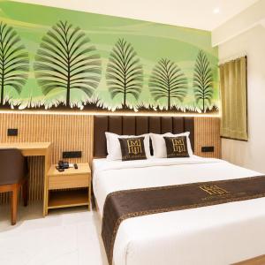 a bedroom with a large bed with a green wall at Hotel Mangla Inn - Dwarka in Dwarka