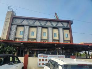 a building with cars parked in front of it at Hotel Suncity Residency in Kālundri