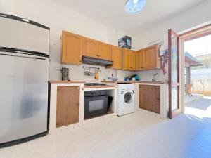 a kitchen with wooden cabinets and a washer and dryer at Only Teens - Baia Verde in Baia Verde