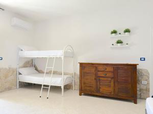 a bedroom with a bunk bed and a wooden dresser at Only Teens - Baia Verde in Baia Verde