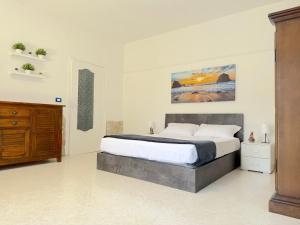 a bedroom with a large bed and a wooden cabinet at Only Teens - Baia Verde in Baia Verde