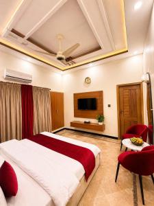 a bedroom with a large bed and a tv at Holiday One Hotel & Suites - Gulshan-3 in Karachi