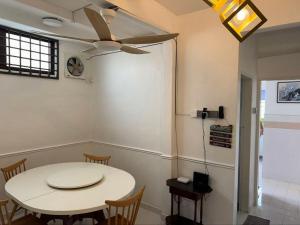 a dining room with a white table and a ceiling fan at 8minit walk to jongke in Malacca