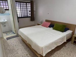 a bedroom with a bed with two colorful pillows at 8minit walk to jongke in Malacca