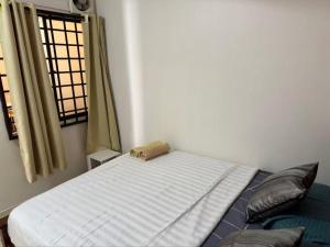 a bed sitting in a room with a window at 8minit walk to jongke in Malacca