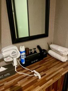 ein Schminktisch mit Föhn, Telefon und Spiegel in der Unterkunft The Last Hotel Nampo in Busan