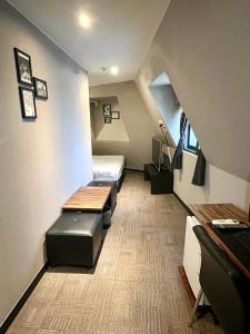 ein kleines Zimmer mit einem Bett und Bänken darin in der Unterkunft The Last Hotel Nampo in Busan