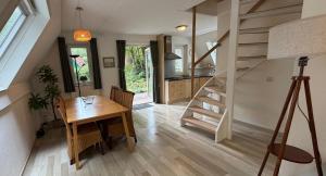 a kitchen and dining room with a table and a staircase at Bosvilla in Harfsen