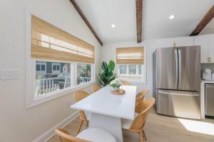 a kitchen with a white table and chairs and a refrigerator at Mermaid Lane #2 in Brighton Beach