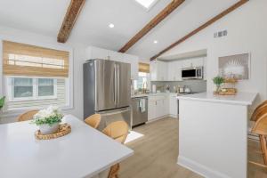 a kitchen with a refrigerator and a table with chairs at Mermaid Lane #2 in Brighton Beach