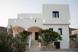 a white house with trees in front of it at Aellia Bay Residences in Alinda