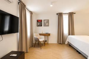 a bedroom with a bed and a chair and a desk at Villa Mater in Trogir +25 photos