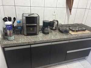 a kitchen counter with a coffee maker on a counter top at Hospedagem da Néli 2 in Aparecida