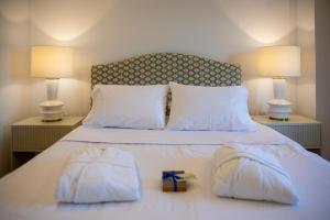 a bed with two towels and a gift on it at Aellia Bay Residences in Alinda