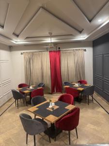 a restaurant with tables and chairs and red curtains at Holiday One Hotel & Suites - Gulshan-3 in Karachi