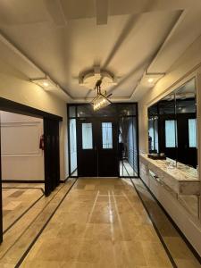a hallway with a black door and a tile floor at Holiday One Hotel & Suites - Gulshan-3 in Karachi