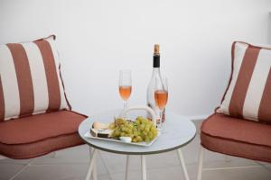 a table with a plate of grapes and two glasses of wine at Aellia Bay Residences in Alinda