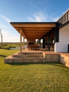 a house with a wooden roof and a patio at Farmstead at ECS winery in Lake Marina