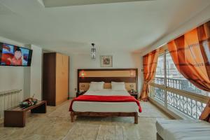 a bedroom with a large bed and a balcony at Hôtel Telemly - Chaine El Djazair in Alger +20 photos