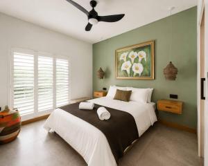 a bedroom with a large bed with a ceiling fan at Farmstead at ECS winery in Lake Marina
