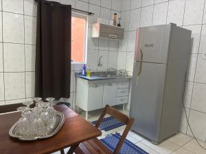 a kitchen with a wooden table and a refrigerator at Hospedagem da Néli 2 in Aparecida +24 photos