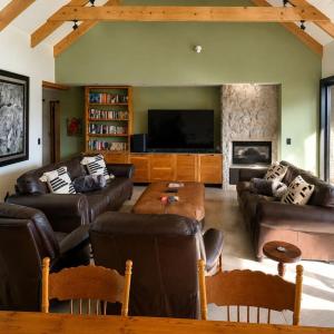 a living room with leather furniture and a flat screen tv at Farmstead at ECS winery in Lake Marina