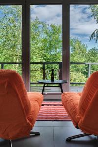 two orange chairs and a table in front of a window at Natura Taszów in Lewin Kłodzki +96 photos