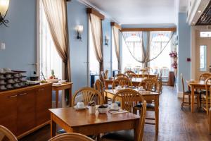 a restaurant with wooden tables and chairs and windows at Hotel As Americas in Aveiro