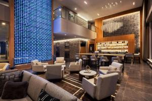 a lobby with couches and chairs and a bar at AC Hotel by Marriott Madison Downtown in Madison