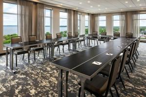 a row of tables and chairs in a room with windows at AC Hotel by Marriott Madison Downtown in Madison