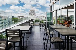 a restaurant with tables and chairs and the capitol building at AC Hotel by Marriott Madison Downtown in Madison