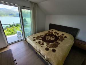 a bedroom with a bed and a large window at Villa Nena Apartment in Mavrovi Anovi