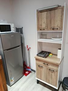 a kitchen with a refrigerator and wooden cabinets at LaKaz Pascale T2 climatisé pour 4 adultes 1 enfant in Ravine des Cabris