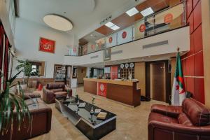a large lobby with leather furniture and a bar at Hôtel Telemly - Chaine El Djazair in Alger