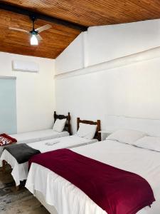 a bedroom with two beds and a ceiling fan at Chalés Terra Santa Capitólio in Capitólio +35 photos