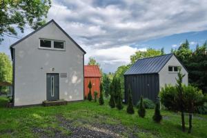 a small white house with a blue door and ashed at Natura Taszów in Lewin Kłodzki