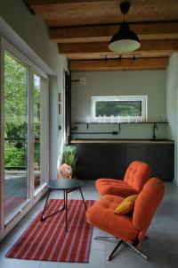 a living room with an orange chair and a table at Natura Taszów in Lewin Kłodzki