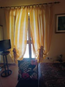 a window with yellow curtains in a bedroom at VILLA flora e Riccardo in Fara San Martino