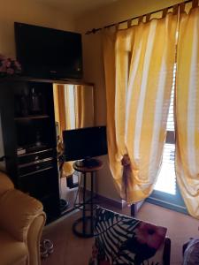 a living room with yellow curtains and a television at VILLA flora e Riccardo in Fara San Martino