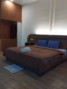 a bedroom with a large bed with blue pillows at Bale Bangket Homestay in Tetebatu