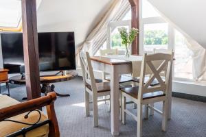 a dining room with a table and chairs and a tv at Villa Rafa in Mielno
