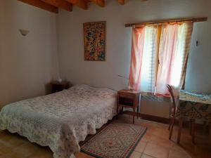 a bedroom with a bed and a window at Les 3 Vignobles in Pardaillan