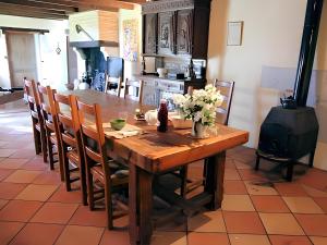 a kitchen with a wooden table with flowers on it at Les 3 Vignobles in Pardaillan
