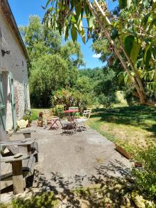 a group of picnic tables and chairs in a yard at Les 3 Vignobles in Pardaillan