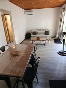 a living room with a wooden table and a couch at LaKaz Pascale T2 climatisé pour 4 adultes 1 enfant in Ravine des Cabris +9 photos
