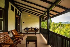 a screened in porch with chairs and a couch at Serenity Wellness in Kuruwita