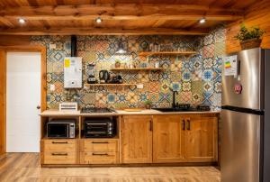 a kitchen with wooden cabinets and a stainless steel refrigerator at Casa de las Flores in Panguipulli