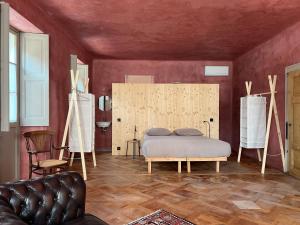 a bedroom with a bed in a room with red walls at Casa Piumogna in Faido