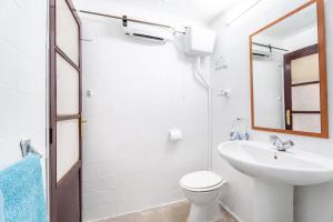 a bathroom with a sink and a toilet and a mirror at Casa Ratón Pérez in Navarrés +27 photos