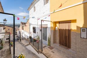 an alley in an old town with flags hanging from buildings at Casa Ratón Pérez in Navarrés